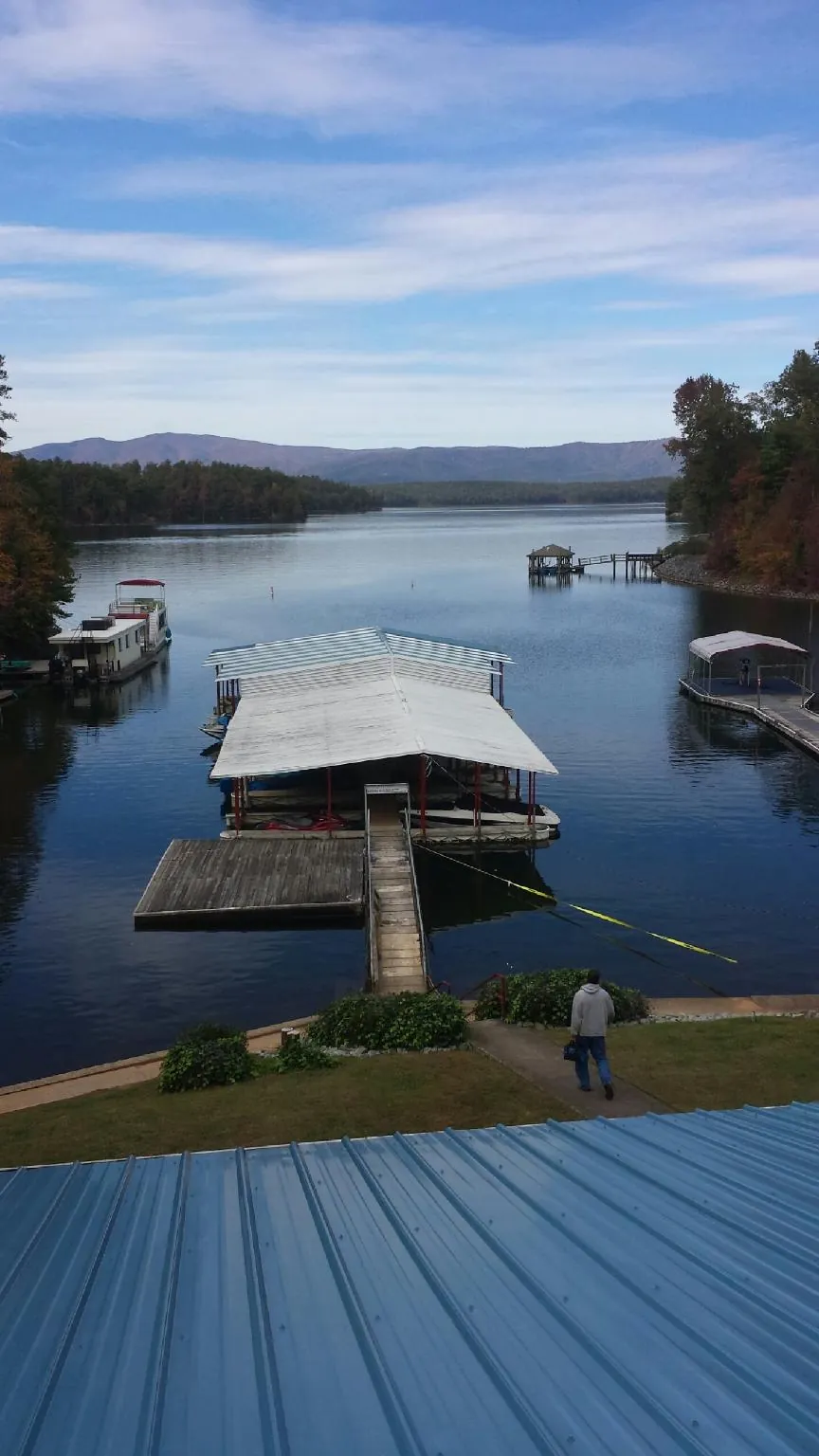 View across a lake from a newly installed blue metal roof in Oakfield