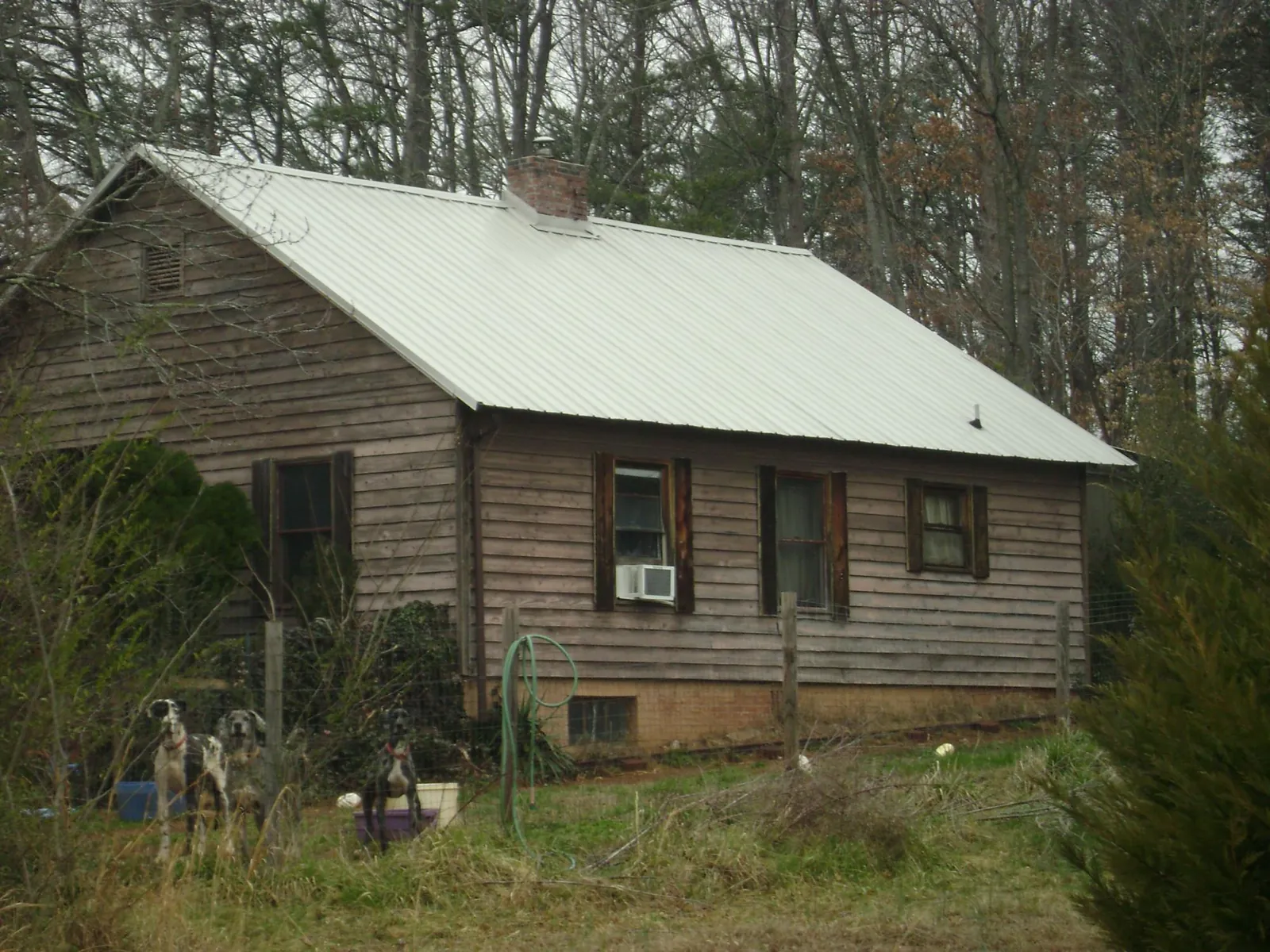 White metal roof on an old wood sided farmhouse, from a Metal Roof Installation job in Oakfield
